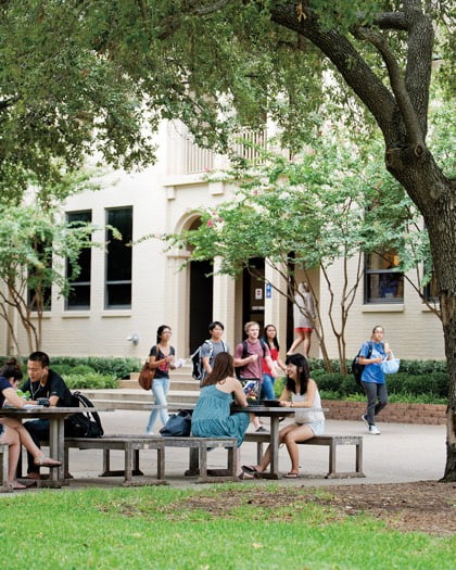 students discussing while sitting on a picnic table