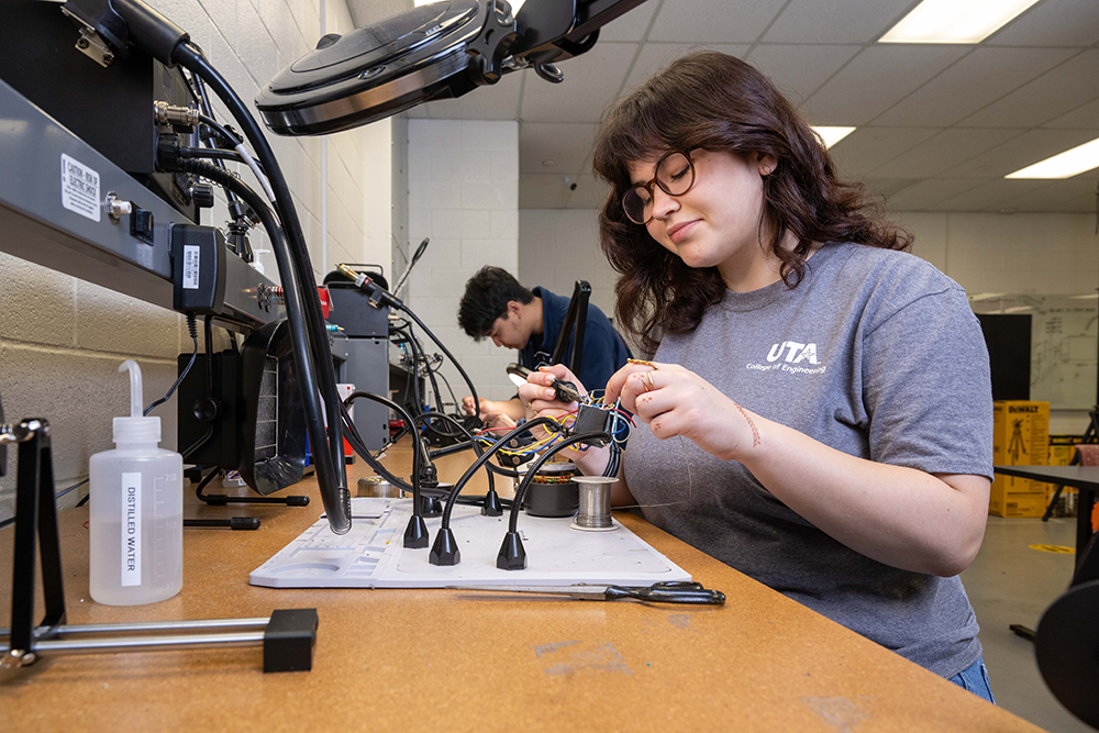 A woman soldering at a desk
