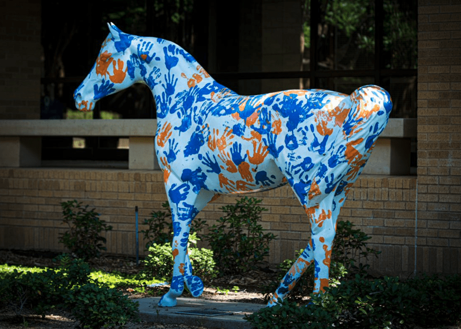 light blue horse statue with blue and orange handprints