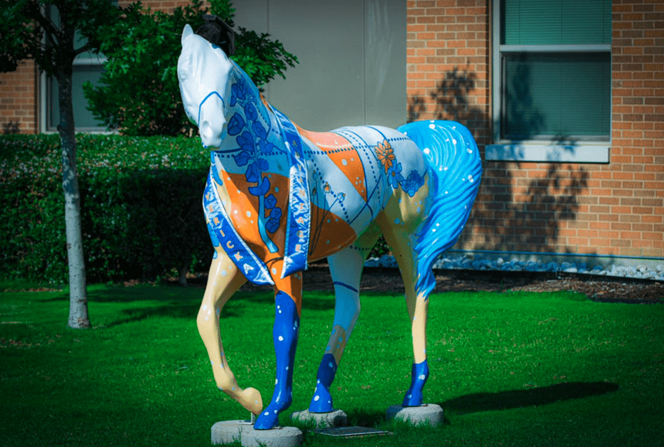 horse statue wearing cap and sash 