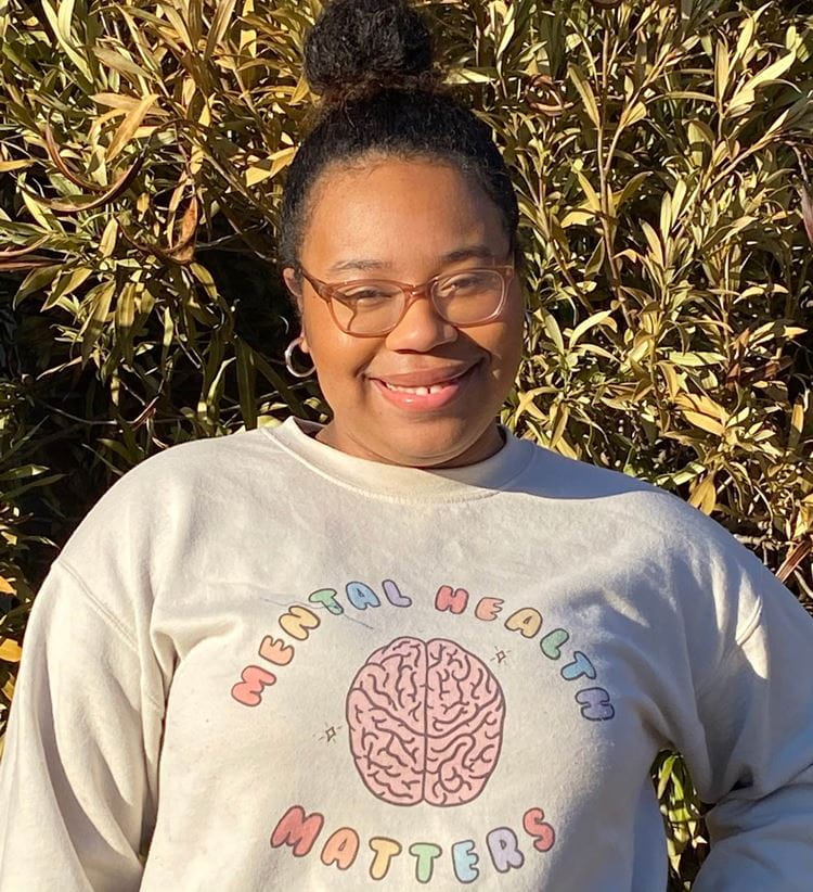 Starr Robinson smiling while she wears a sweater that says "mental health matters"