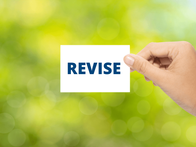 Hand holding sign that reads: revise on green background