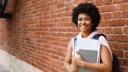 A girl smiling and holding a book in her hand