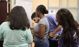 C S L ambassadors writing on a whiteboard during one of their meetings