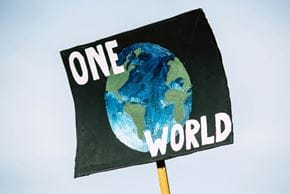 poster that says "one world" with a painting of the world behind it