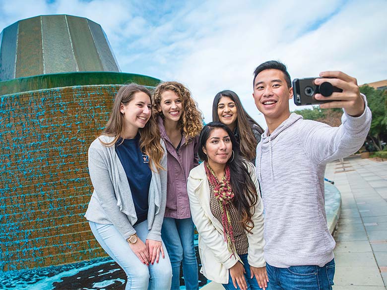Students taking a selfie in front of the Fine Arts Building Fountain.