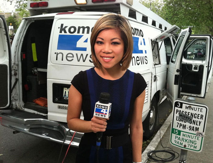 Elizabeth Dinh reporting in front of news van