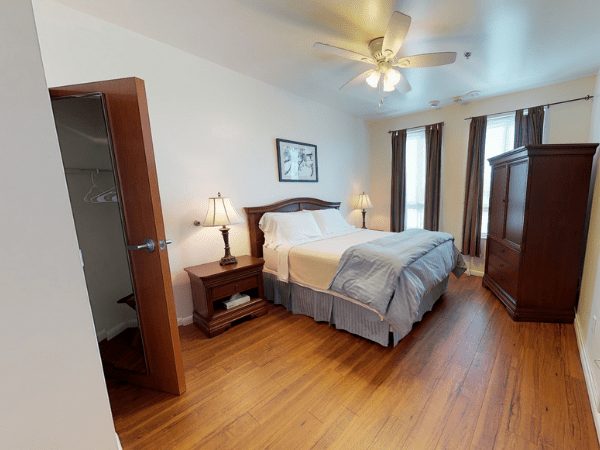 The Lofts at College Park  Bedroom furnished with a bed, cabinet, bedside table and closet