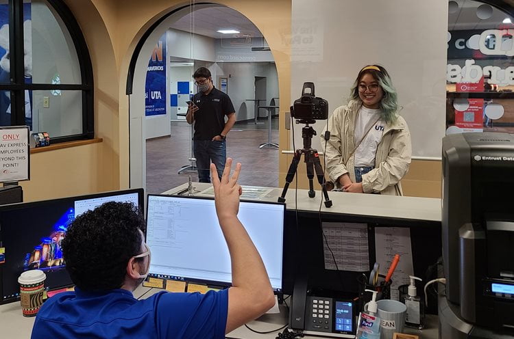 behind the counter view of a student getting their photo taken for their ID card