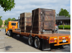 a moving truck carrying giant slabs