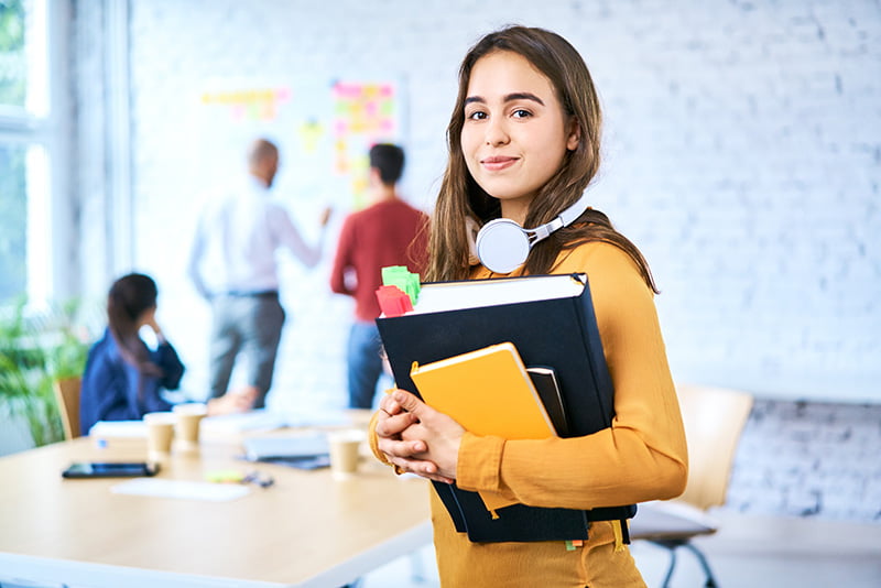 Student holding book wearing headphones