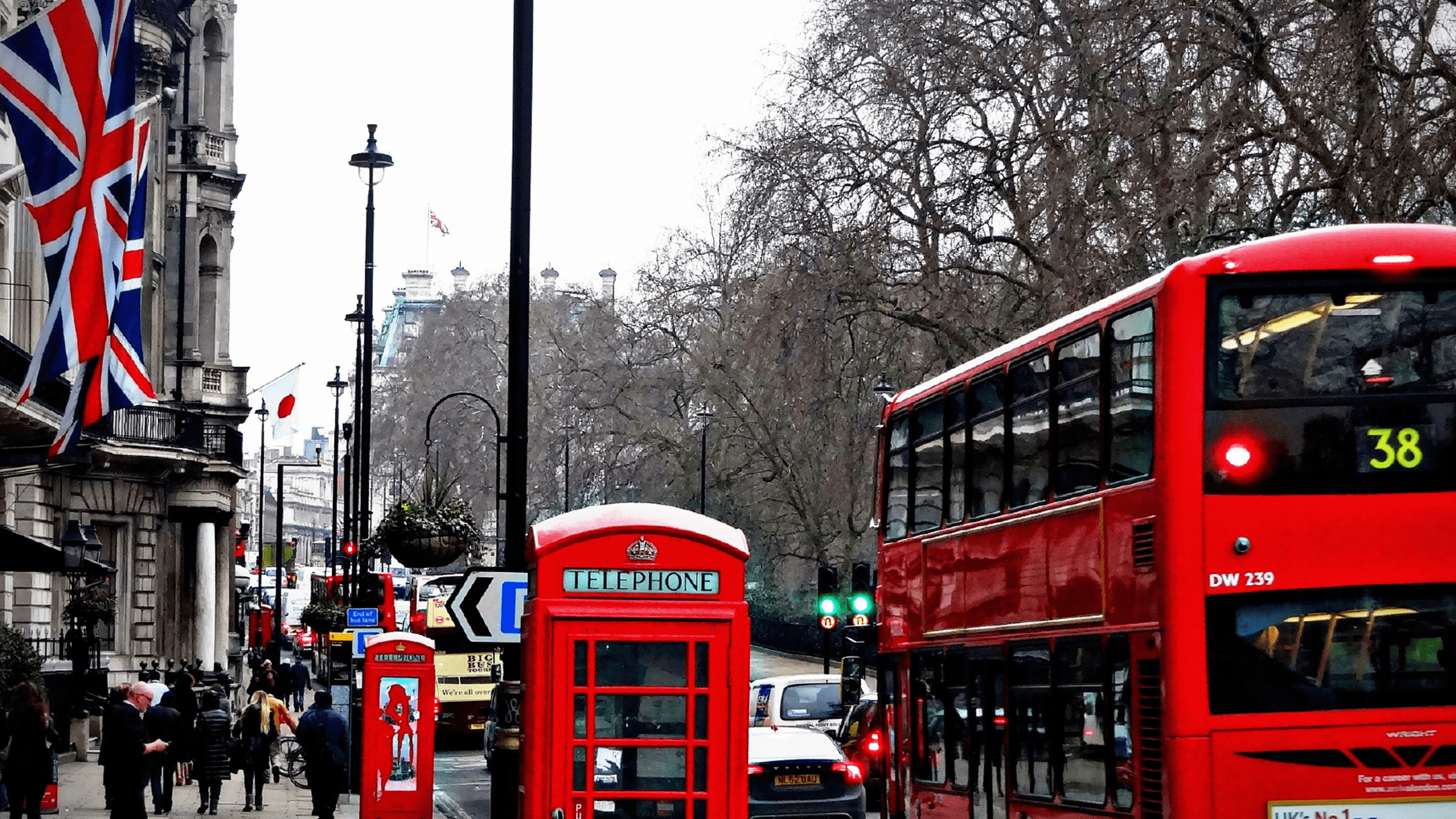 Image of London featuring the British Flag, a telephone booth, and a double decker truck.