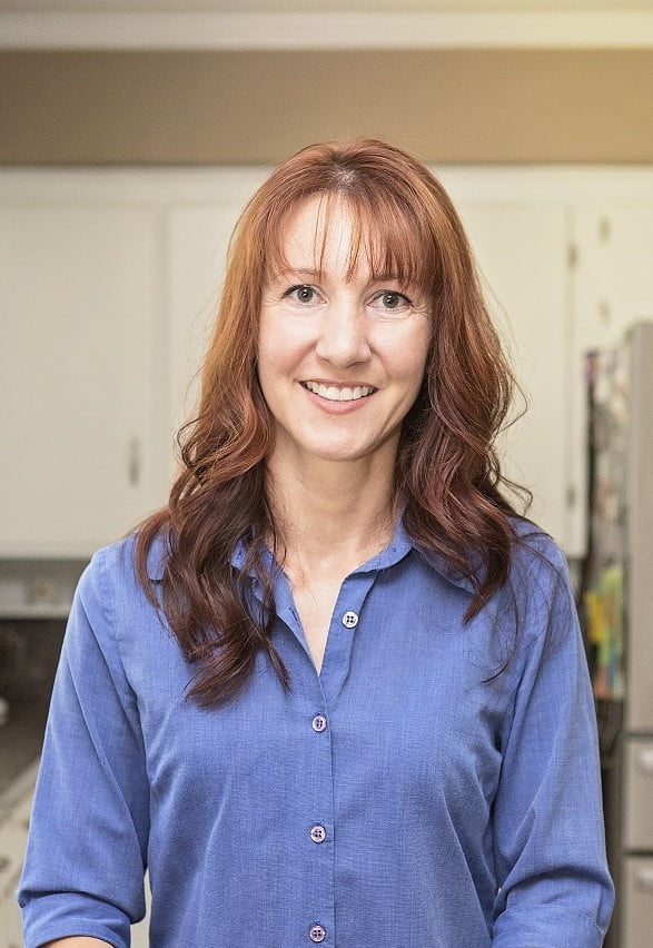 Christy Brady smiling, wearing a long sleeve button up