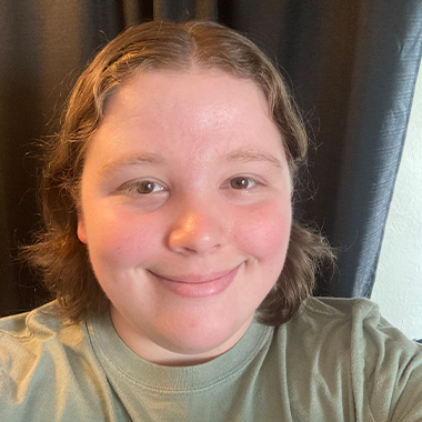 Marie Bissell with short hair and a simple shirt, smiling