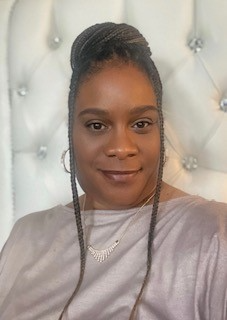 Stephanie Wilson smiling wearing a plain shirt, earrings, and a necklace