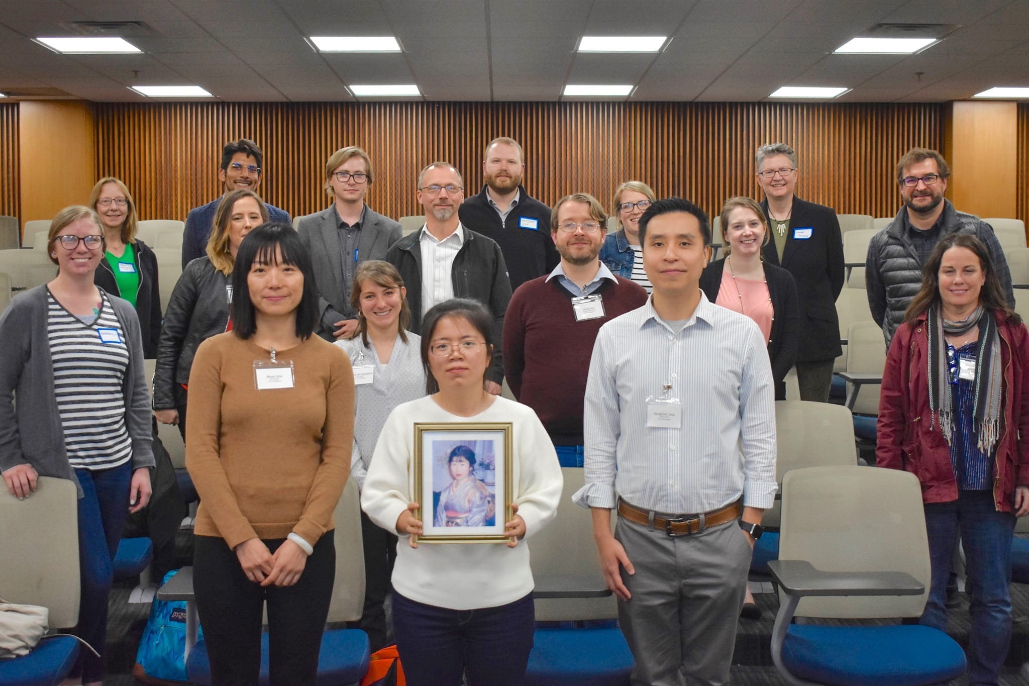 Group shot of 18 of the attendees at the UTASCILT conference, with the prize winners in the front row. The woman in the middle is holding a framed photograph of Yumi Nakamura.
