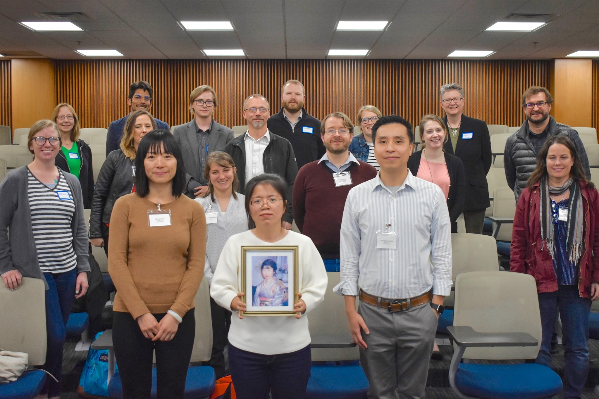 Group shot of 18 of the attendees at the UTASCILT conference, with the prize winners in the front row. The woman in the middle is holding a framed photograph of Yumi Nakamura.