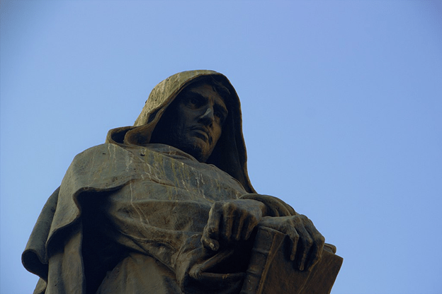 Statue that wears a hood and holds a book