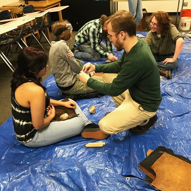 An image of pairs of people studying about rocks in the archaeology lab.