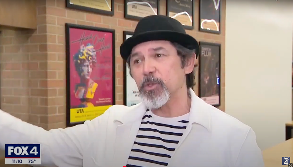 Actor Lou Diamond Phillips being interviewed in front of theatre posters.