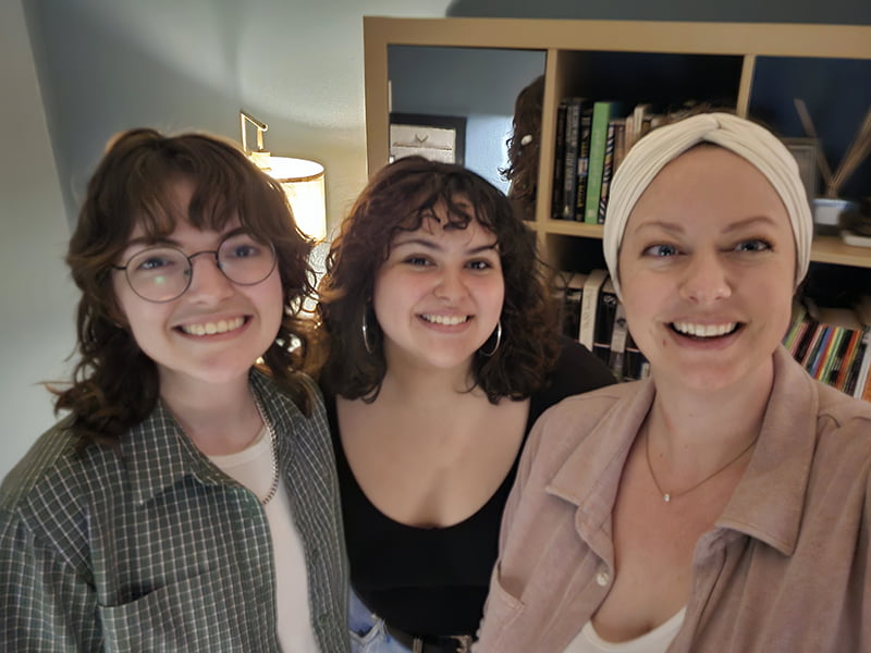 Paloma, Edith, and Libby smiling into camera