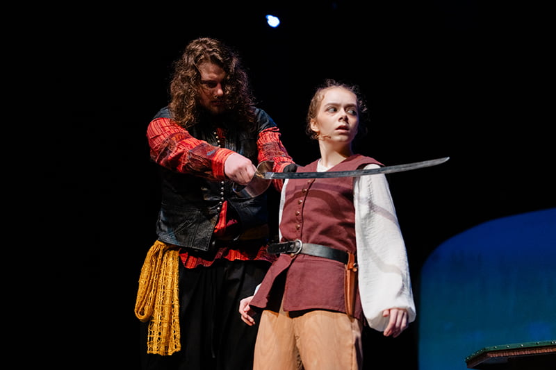 Pirate with sword at the neck of Jim Hawkins