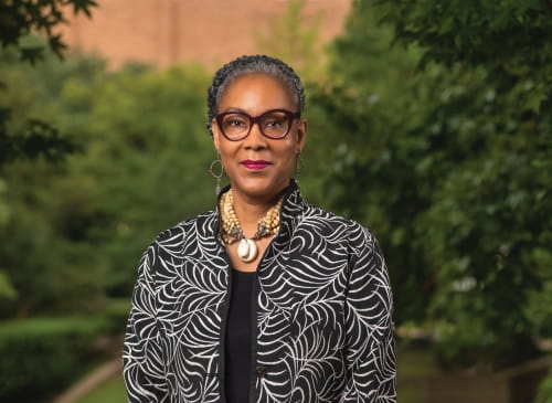 Photo of UTA college of business dean of diversity, racial equity, and inclusion Dr. Myrtle Bell. With trees in the background.