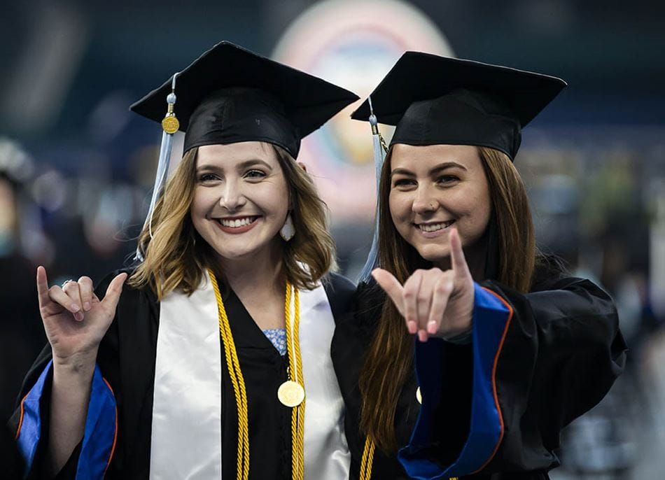 two students doing the mav up at commencement