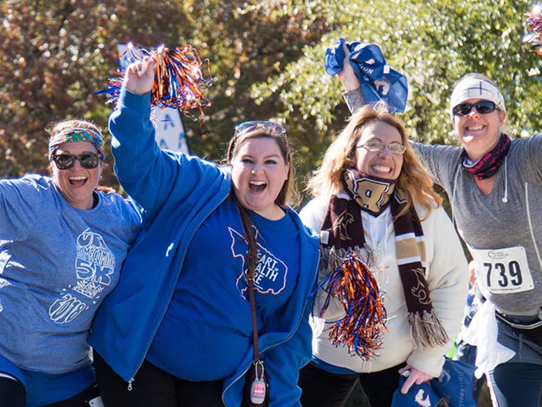 4 students cheering with pom-poms