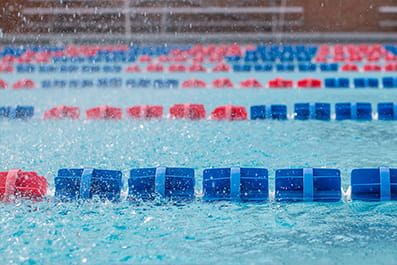 A swimming pool with red and blue plastic lane dividers.