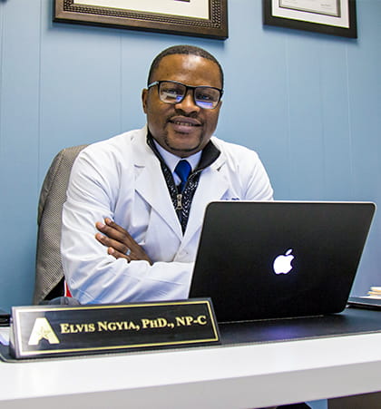 Male PhD Nurse Practitioner sitting in front of laptop
