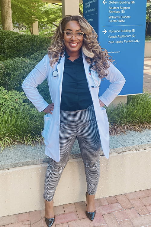 Kiana Lacy standing outside of a medical center wearing medical jacket