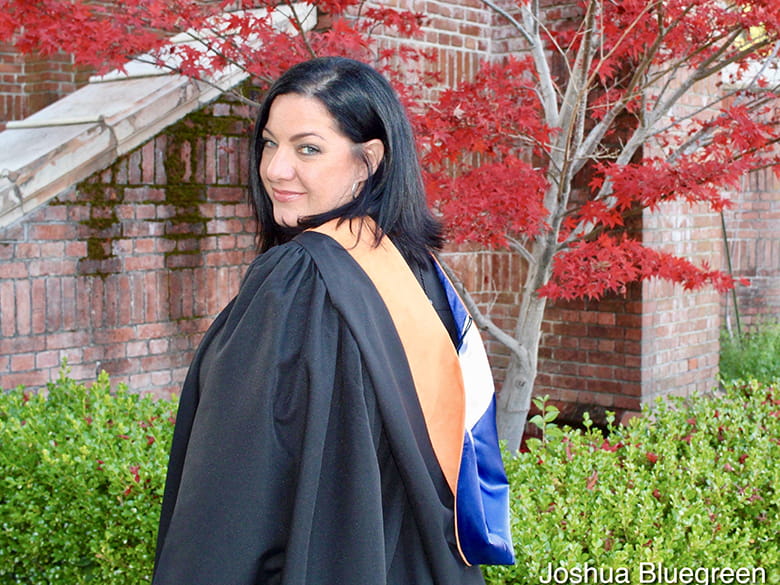 Susan Grafton posing outside wearing graduation gown