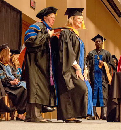 female graduate receiving hood