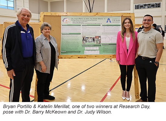 Kinesiology Research Day male and female winning students pose next to poster