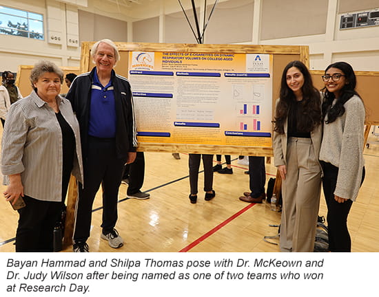 Kinesiology Research Day students pose next to poster