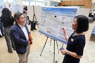 Zui Pan explaining her research poster at at CONHI Research Expo