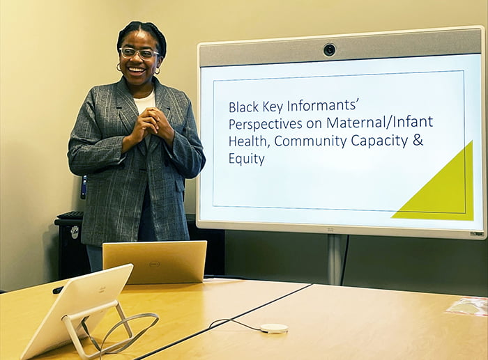 Ariel Hall standing next to a presentation board