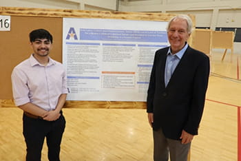 Arturo Valles standing with poster presentation