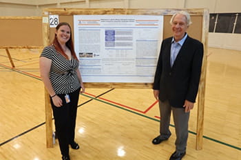 Claire Oliver-Dehaven standing with poster presentation