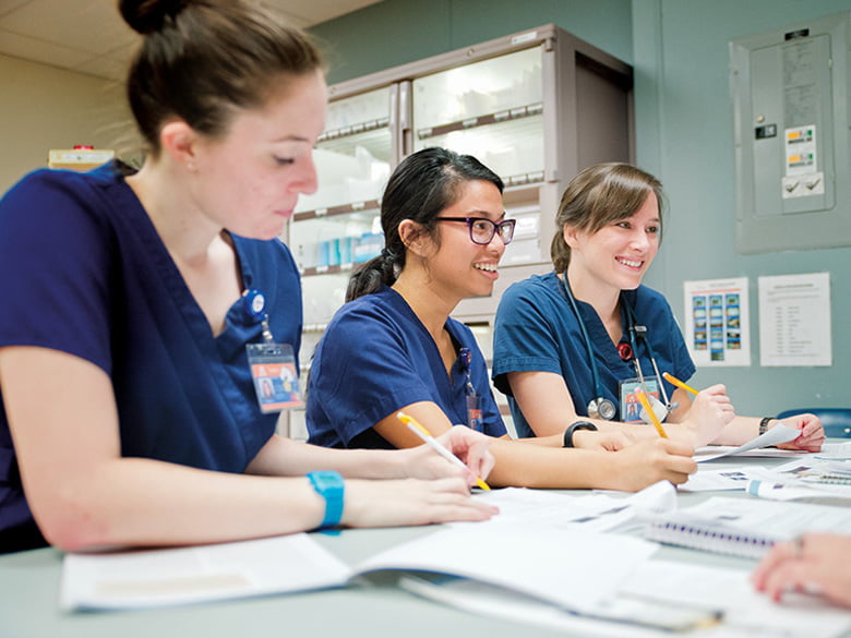 Nursing students talking and doing paperwork