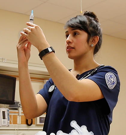 Nursing student Vanessa Galvan prepares an injection for a simulated patient. 