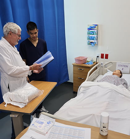 A nursing student adjusts an oxygen mask on a simulated patient.