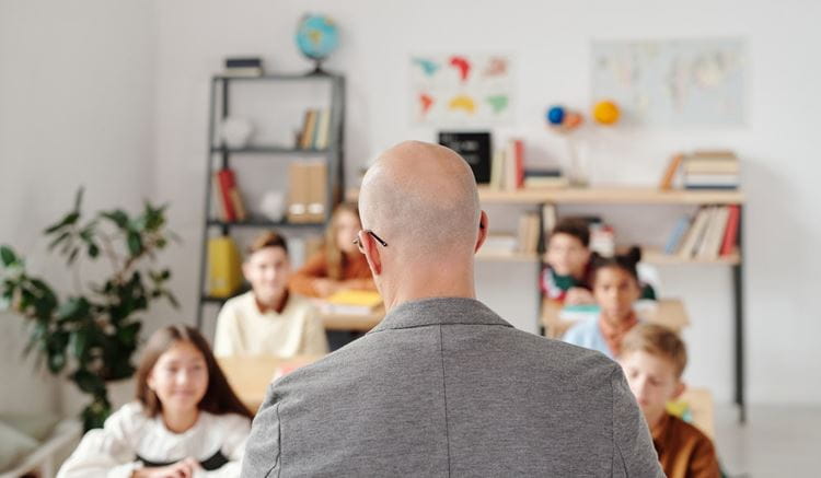 Teacher looking at a classroom full of children 
