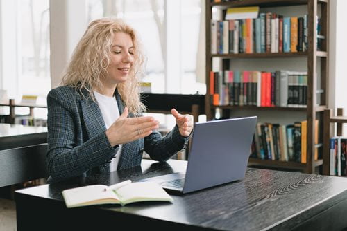 Woman on laptop talking on a video conference call.