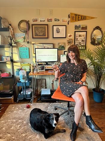 Photo of Emily Cole inside her home office with her dog