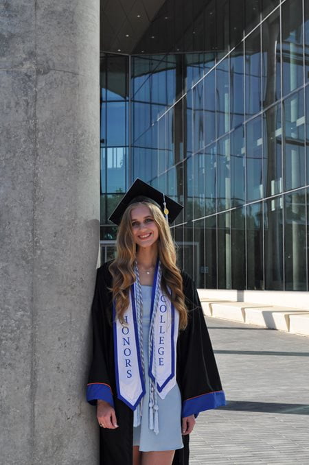 Photo of Ashley Kevin leaning on pillar in front of the SEIR building