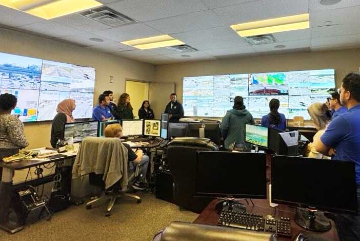 ITE students in a traffic control center waching monitors of traffic in a city.