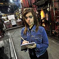 An industrial engineering student takes notes in a factory
