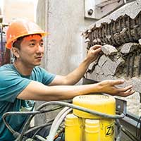 Student working with concrete in the Civil Engineering Laboratory Building